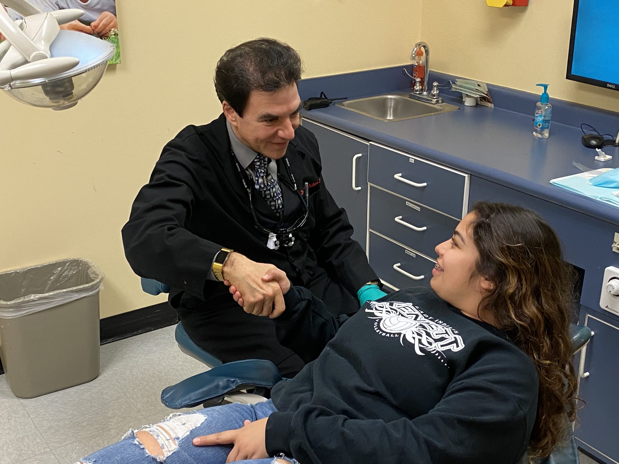 dentist shaking teen patients hand
